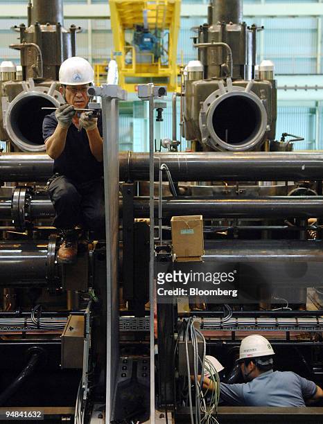 Employees work on the production line manufacturing ship engines at Doosan Engine Co.'s plant in Changwon, South Korea, on Friday, Sept. 26, 2008....