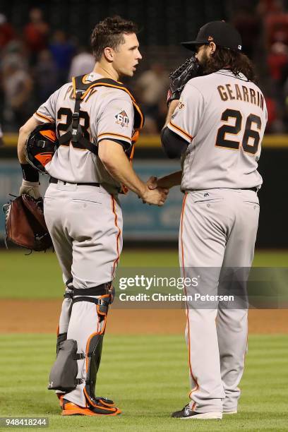 Relief pitcher Cory Gearrin and catcher Buster Posey of the San Francisco Giants celebrate after defeating the Arizona Diamondbacks 4-3 in 10 innings...