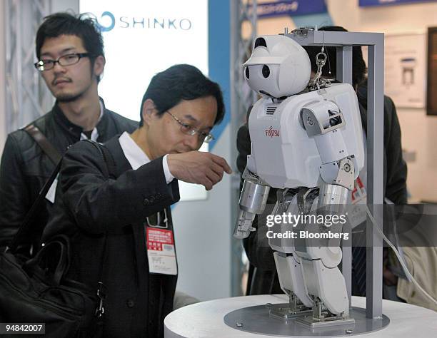 Visitors look at a Fujitsu Ltd. HOAP-3 robot at the International Robot Exhibition in Tokyo, Wednesday, November 30, 2005. The one-meter tall HOAP-3...