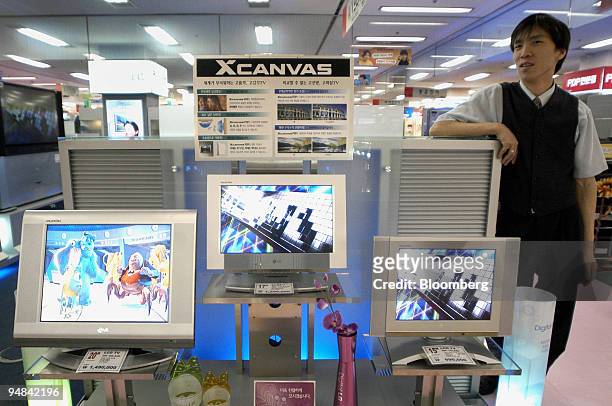 Sales clerk waits for customers next to LG Electronics Inc.'s LCD TV monitor at a shop in Seoul Wednesday, April 21, 2004.