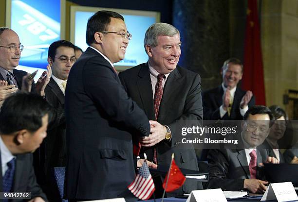 Larry Dickenson, Senior Vice President of Boeing Commercial Airplanes Sales, right, shakes hands with Li Hai, President of China Aviation Supply...