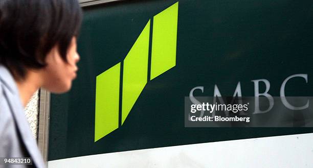 Woman walks past a Sumitomo Mitsui Banking Corp. Branch office in Tokyo, Japan, on Wednesday, Sept. 24, 2008. Sumitomo Mitsui Financial Group Inc....