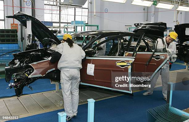 Workers on the production line at a Nissan Motor Co. And Dongfeng Motor Corp. Joint venture factory, assemble Nissan Teana cars in Xiangfan City,...