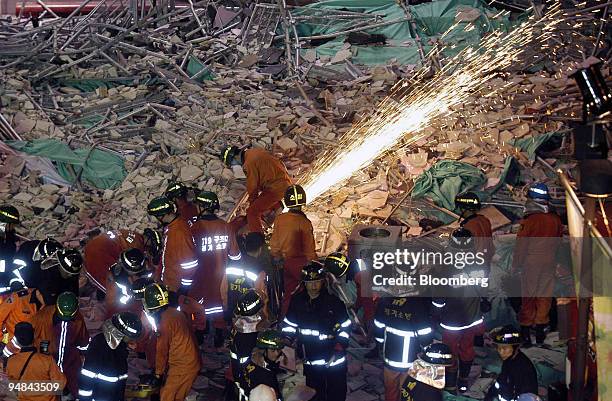 Rescue workers and fire fighters remove rubble where scaffolding collapsed during repair work at a LG Department Store in Bucheon, Korea, near Seoul,...