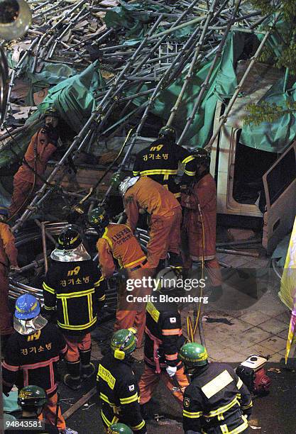 Rescue workers and fire fighters remove rubble where scaffolding collapsed during repair work at a LG Department Store in Bucheon, Korea, near Seoul,...