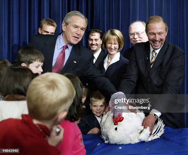 United States President George W. Bush pets Marshmallow the National Thanksgiving Turkey, along with local school children after pardoning the bird...