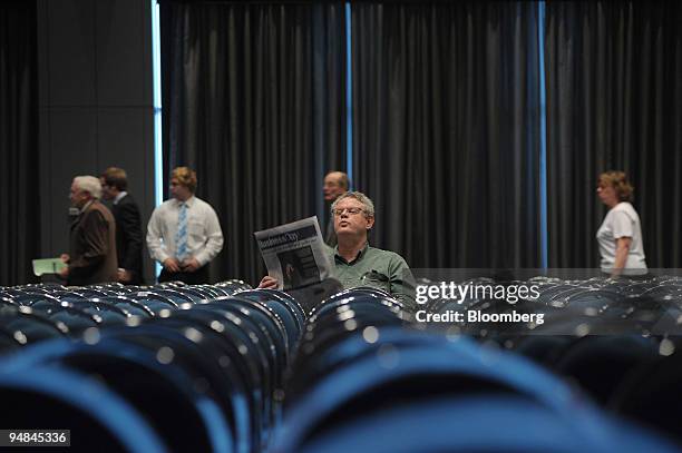 Shareholder reads a newspaper as the venue fills up for the BHP Billiton Ltd. Annual general meeting in Melbourne, Australia, on Thursday, Nov. 27,...