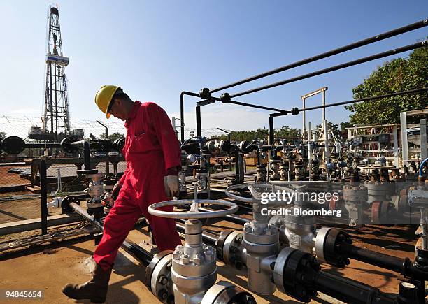 Worker checks a pumping and filtering station at a PTT Exploration & Production Pcl drilling site near the company's central processing plant in Lan...