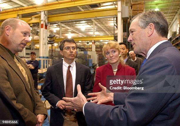 United States Department of Commerce Secretary Donald L. Evans, right, talks with Ariel Corporation Vice President's Kent Dubbe, left, Tom Rastin,...