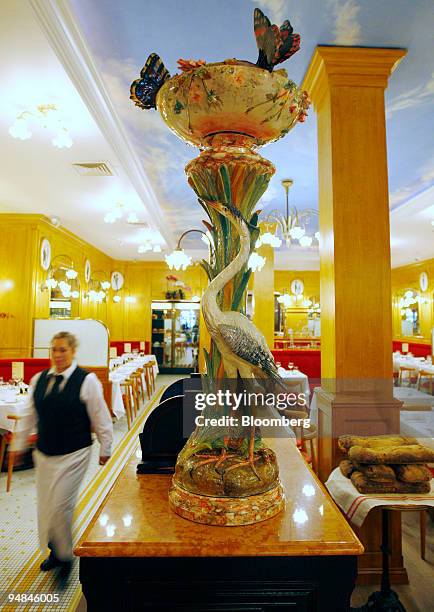 Waitress walks through the dining room of Benoit in New York, U.S., on Monday, April 28, 2008. Alain Ducasse's Benoit isn't just another Midtown...