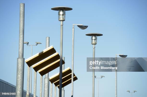 Solar panels stand next to street lights in Port Adelaide, South Australia, on Monday, April 2, 2018. A plan by Tesla Inc. To build the world's...