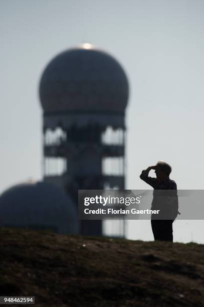 Person looks into the distance on April 08, 2018 in Berlin, Germany. In the background there is a building of the former air traffic control and...