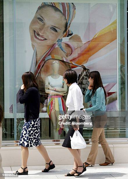 Pedestrians walk past a window display in Coach Inc.'s new shop in Tokyo's Marunouchi district Thursday, April 15, 2004. Japanese retail sales fell...