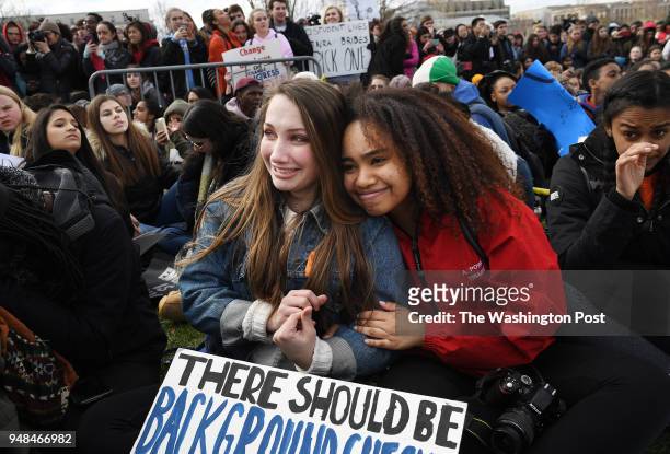 Poolesville High School students, Alice Walker left, and Rani Powell right, embrace during a school walkout rally against gun violence outside the...