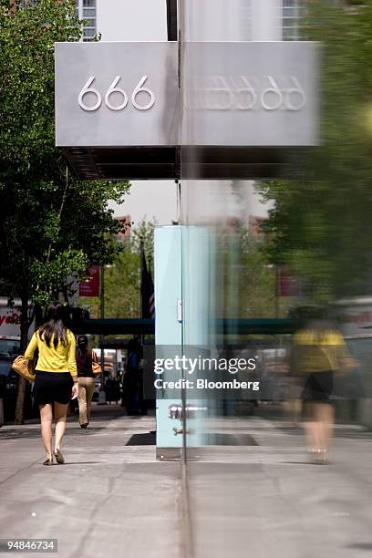 Woman walks past the entrance to 666 Fifth Avenue in New York, U.S., on Friday, April 25, 2008. Carlyle Group, the world's second-largest...
