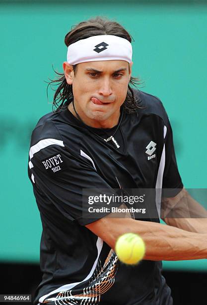 David Ferrer of Spain keeps his eye on the ball as he returns it to Gael Monfils of France during their quarter final match at the French Open in...