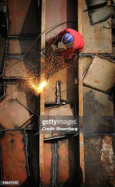 Shipyard worker cuts up pieces of the MSC Napoli cargo ship, as it lies in a dry dock at the Harland and Wolff ship builders in Belfast, Northern...
