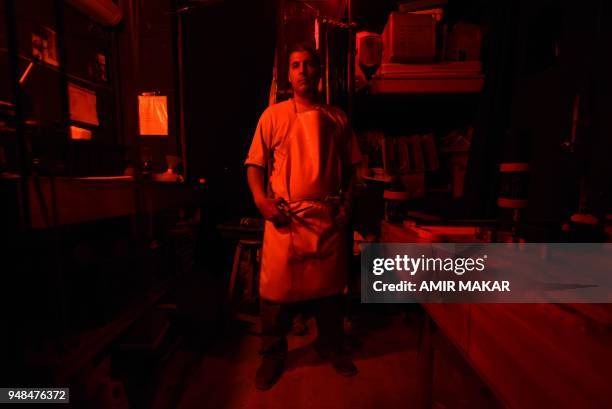 Mohamed el-Maymony, a 38-year-old Egyptian darkroom technician poses for a picture at a darkroom in downtown Cairo on April 11, 2018. - El-Maymony,...