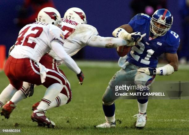 New York Giants running back Tiki Barber has the ball stripped from his hands by Arizona Cardinal lnebacker Ronald McKinnon as safety Kwame Lassiter...