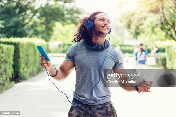 cheerful man in the park listening to music and dancing - humming stock pictures, royalty-free photos & images