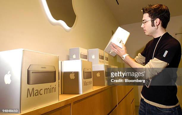 An employee at a San Francisco, California Apple Computer retail location, removes a Mac mini from a display shelf on Saturday, January 22, 2005.