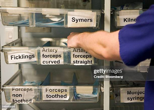 Doctor chooses instruments for surgery at a hospital in London, U.K., on Thursday, Nov. 20, 2008. Funding to tackle hospital infections such as...