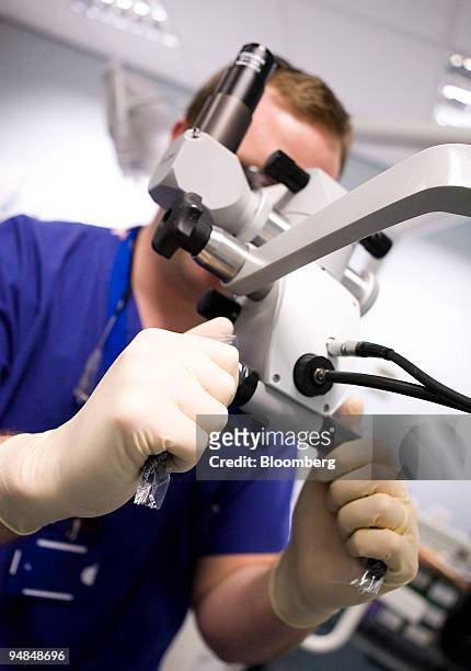Doctor looks through a surgical microscope at a hospital in London, U.K., on Thursday, Nov. 20, 2008. Funding to tackle hospital infections such as...