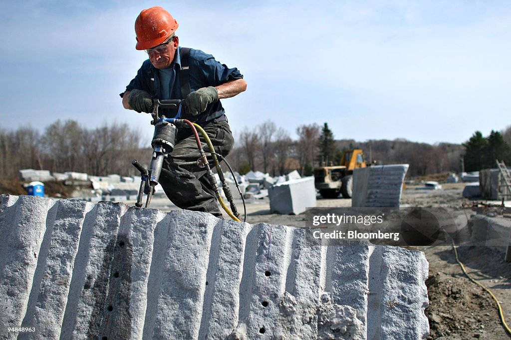 Ronald Percy works on a piece of granite near a Rock of Ages