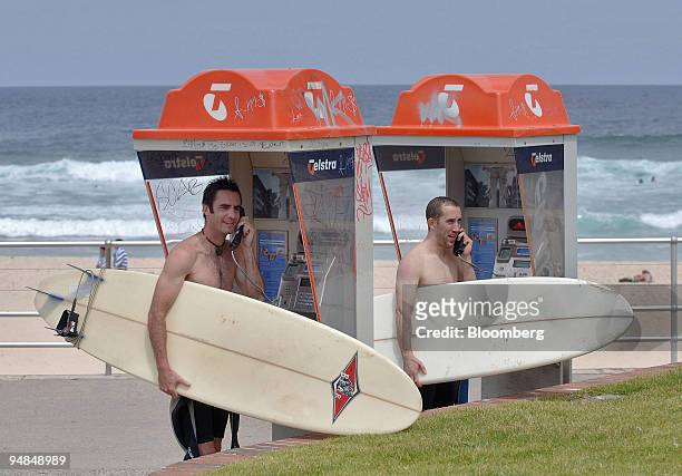 Pair of surfers make calls at Telstra Corp. Phone booths at Bondi Beach in Sydney, Australia Monday, November 21, 2005. Telstra Corp., Australia's...