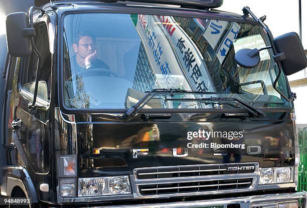 Truck driver waits in a Mitsubishi Fuso Fighter truck in Tokyo on Wednesday, December 8, 2004. DaimlerChrysler AG, the world's largest truckmaker,...
