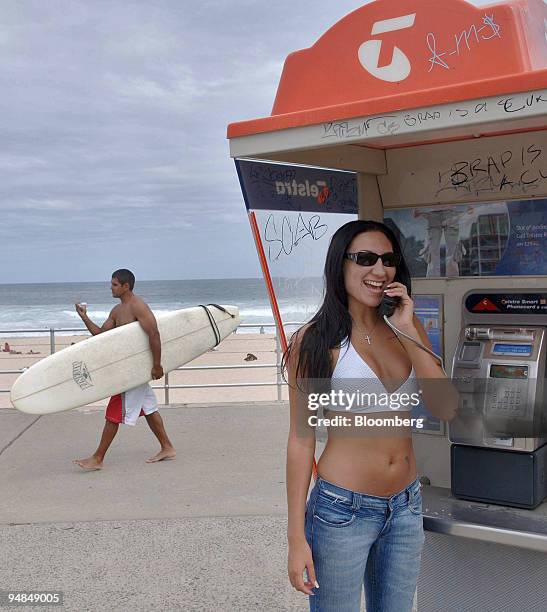 Sunbather makes a call at a Telstra Corp. Phone booth at Bondi Beach in Sydney, Australia Monday, November 21, 2005. Telstra Corp., Australia's...
