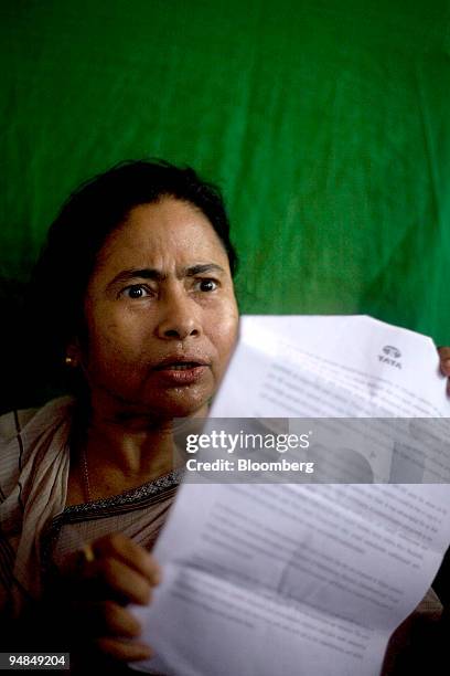 Mamata Banerjee, head of the Trinamool Congress party, holds a letter from Tata Motors during a protest in front of the unfinished Tata Nano plant in...