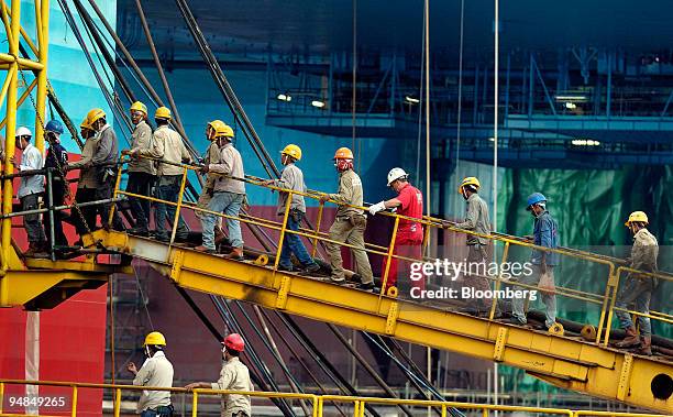 Keppel Corp. Employees cross a bridge onto an oil rig under construction at the company's FELS shipyard, in Singapore, on Tuesday, April 22, 2008....