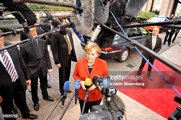 Angela Merkel, Germany's chancellor, talks to the press as she arrives for an informal summit of European heads of state at the EU Council building...