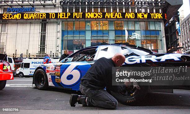 Show Car hauler, Paul Jackson cleans the tire of a NASCAR show car outside the NASDAQ Marketsite in the Times Square area of New York, Thursday,...