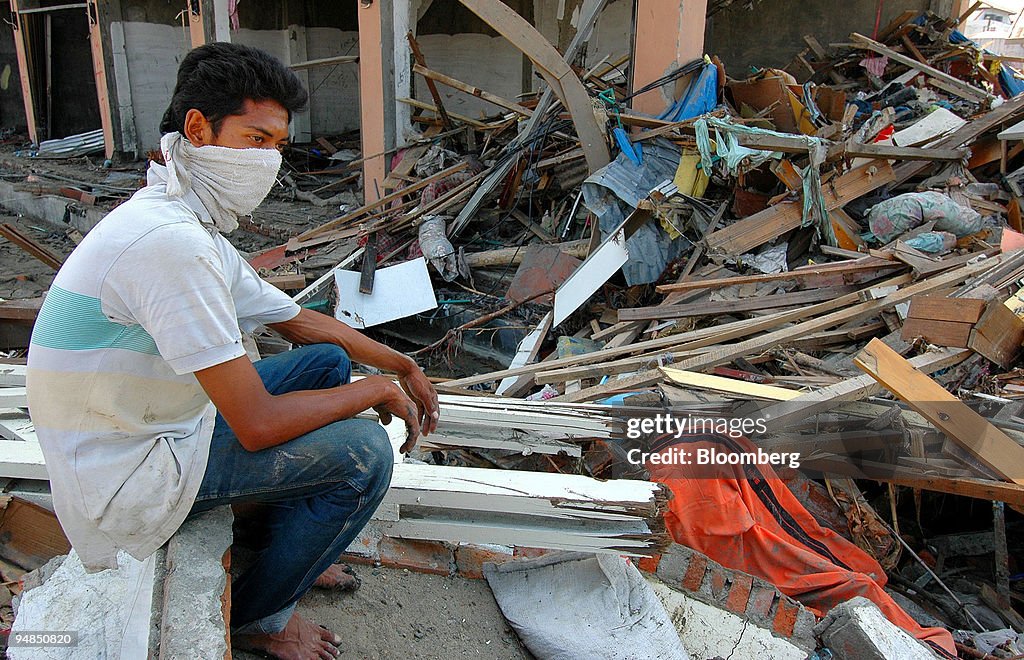 A young Acehnese man, his face covered against the smell of