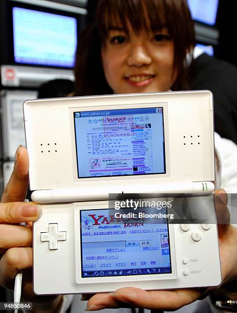 Model holds a Nintendo DS Lite handheld game console displaying the Yahoo! Japan search engine Web page following a press briefing in Tokyo...