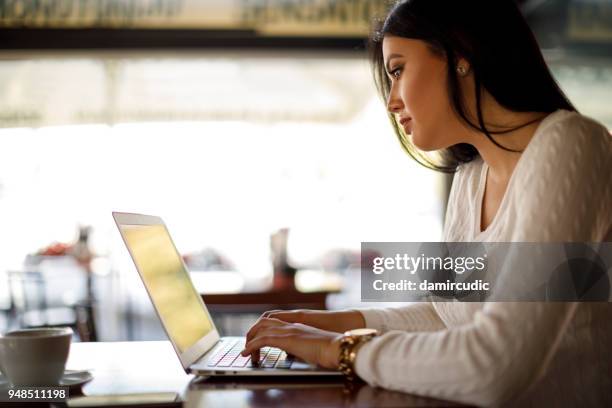 junge frau in einem café mit laptop - student girl using laptop computer and smart phone stock-fotos und bilder