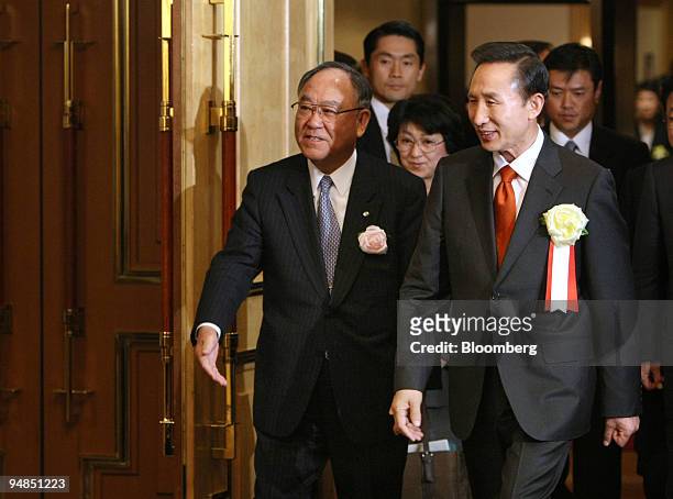Lee Myung Bak, South Korea's president, right, accompanied by Fijio Mitarai, chairman of the Nippon Keidanren and chairman and chief executive...