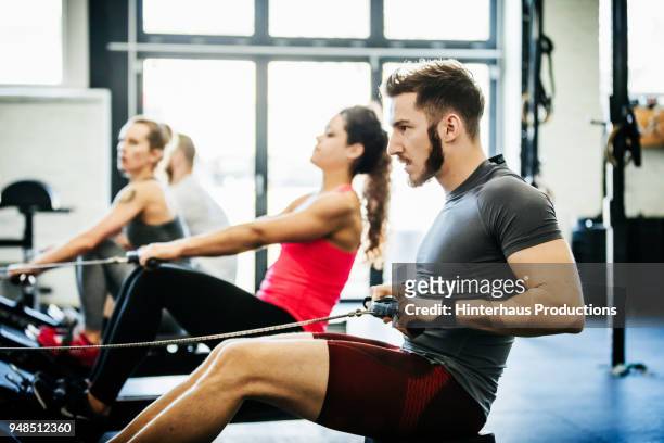 people using rowing machines at gym - running shorts stock pictures, royalty-free photos & images