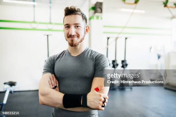 portrait of fitness trainer at gym - young sporty man stockfoto's en -beelden