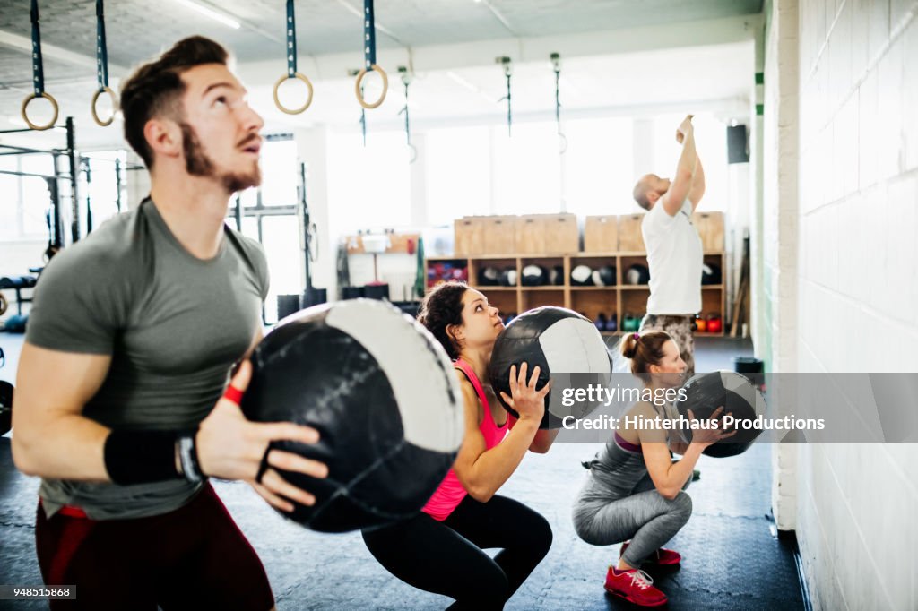 Fitness Enthusiasts Keeping Fit Using Weighted Balls