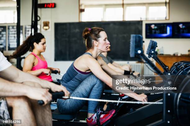 Fitness Team Using Rowing Machines Together