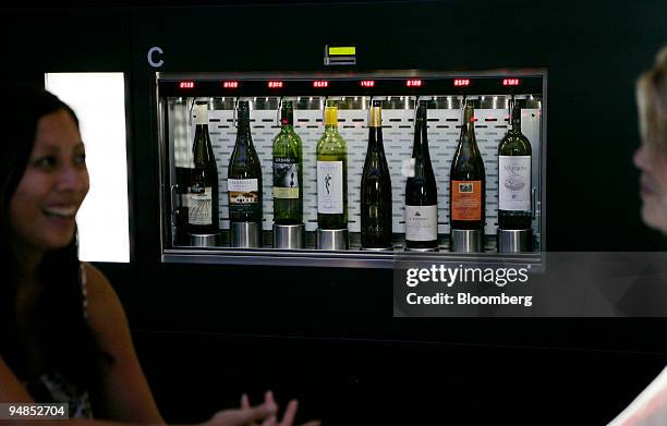 Patrons drink at Clo, with an automated wine machine in the background, located in the Time Warner Center in New York, U.S., on Friday, Aug. 29,...
