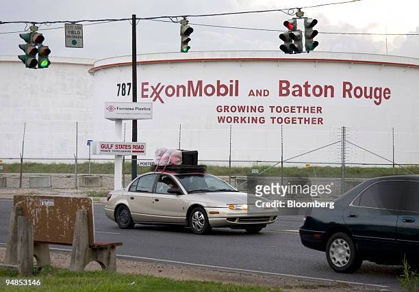 Car loaded with belongings drives past an Exxon Mobil Corp. Refinery in Baton Rouge, Louisiana, on Sunday, Aug. 31, 2008. At least eight refineries...