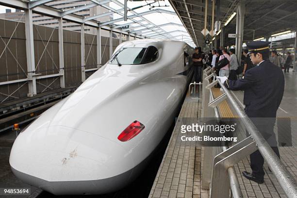An employee works near a N700 Shinkansen bullet train developed by West Japan Railway Co. And Central Japan Railway Co. At Shin-Osaka Station in...