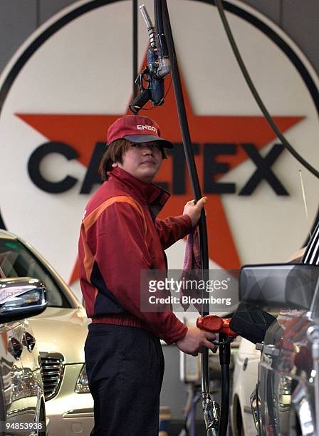 An employee pumps gas at a Caltex petrol station in Tokyo on Friday, November 26, 2004. Japanese core consumer prices fell in October, extending a...