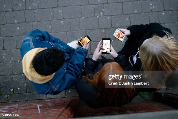 group of friends on their mobile phones shot form above in the fading light - adolescencia fotografías e imágenes de stock