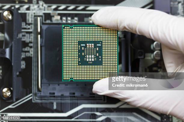 human hand to installing integrated circuit, cpu - semiconductor imagens e fotografias de stock