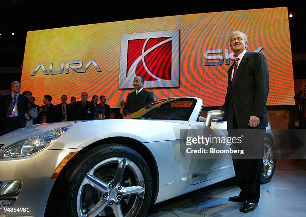 Ed Welburn, center, VP of GM Design and Gary Cowger, right, President of GM North America, pose for the media for the unveiling of the Saturn Sky,...